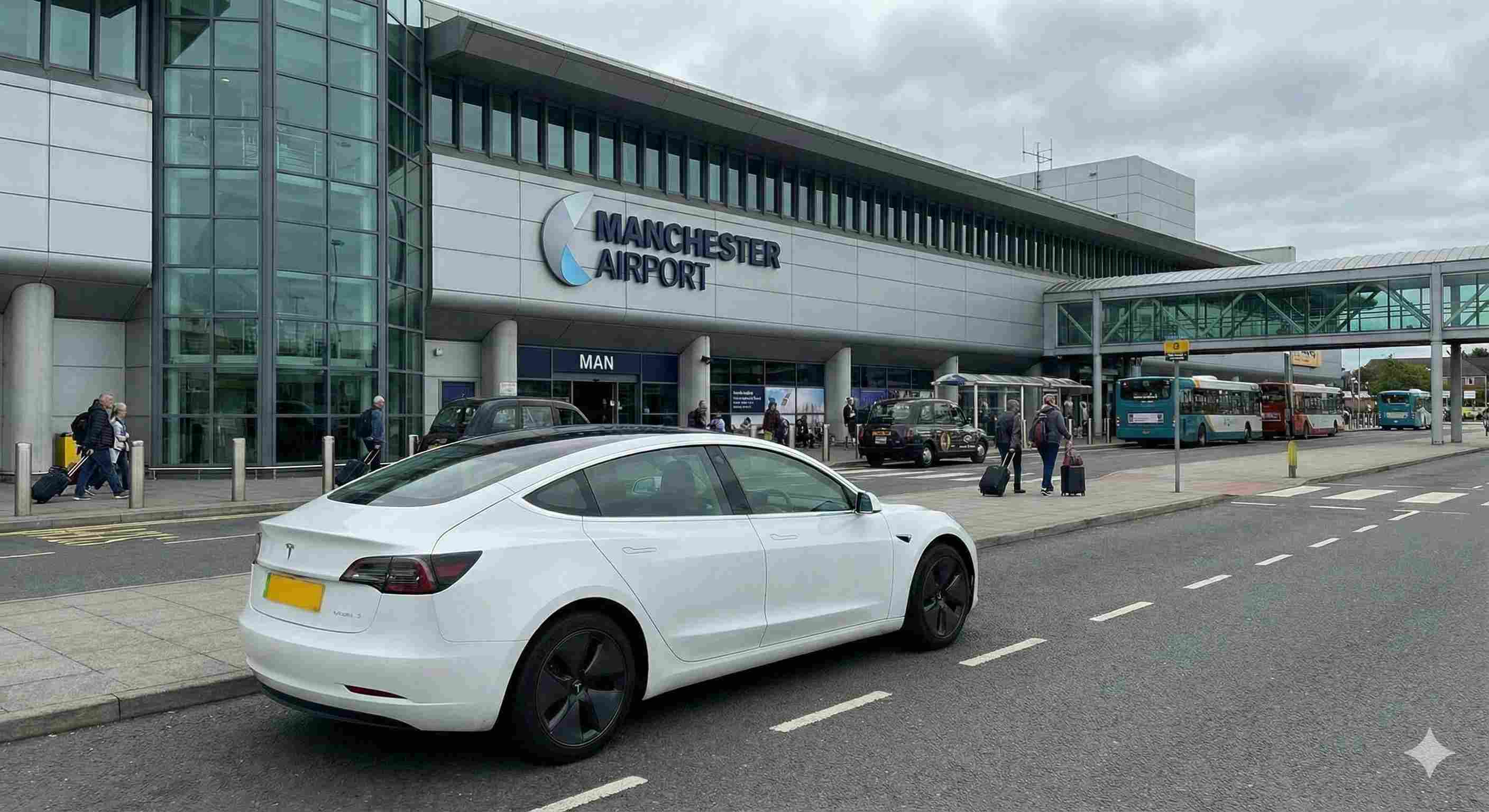 White Tesla Model 3 electric taxi at Manchester Airport terminal - Professional airport transfer service from North Wales